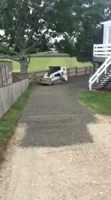Bobcat metalling and shaping a driveway